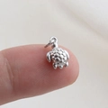 Macro shot of silver turtle charm showing fine shell details and micro scale on finger - Silver Turtle Style(26)