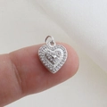 Dettaglio di un ciondolo a cuore in argento con pavé di zirconi su un dito - Stile Rilievo Cuore Pavé Zirconia Argento (16)