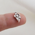 Macro di un piccolo ciondolo a margherita in argento vintage sulla punta di un dito - Stile Fiore Margherita Invecchiato Vintage Argento (20)