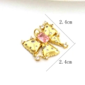 Detailed view of golden butterfly pendant with pink gemstone and zircon settings - Pink Rectangular Gem Bow Style (11)