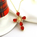 Detailed close-up of a gold cross pendant with red pear-cut crystals and Virgin Mary medal - Big Red Style