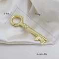 Polished gold vintage key pendant, 9.7cm long, shown on elegant white silk background - Vintage Large Key Shape (01)