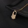 Détail du collier pendentif cadenas doré orné de zircons noirs et blancs design oeil - Style Cadenas à Motif d'Œil (210999)