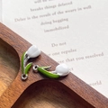 Detailed macro shot of white tulip charms with green leaves on a rustic wooden tray - White Silver Ring