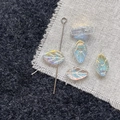 Detailed macro view of iridescent glass leaf beads with metallic pin for DIY jewelry making - White Leaf