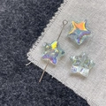 Macro shot of iridescent glass star beads with AB coating and silver metal pin for DIY jewelry - Blue Green Star