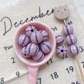 Close-up of purple striped resin round beads with central holes for DIY jewelry making - Style 21 Purple Striped 12mm