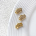Makroansicht der vergoldeten gebogenen Röhre mit Zirkonia-Mikropflaster für DIY-Schmuck - Gold