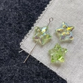 Macro view of light green star-shaped glass beads with iridescent AB coating and drill hole - Green Star