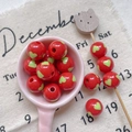 Close-up of red acrylic round beads with green heart pattern for DIY jewelry making - Style 15 Red Striped 12mm