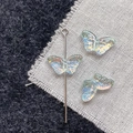 Iridescent glass butterfly beads for DIY jewelry making on textured fabric background - Blue Green Butterfly