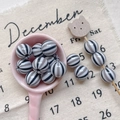 Close-up of striped acrylic beads in a pink spoon for DIY handmade jewelry crafting - Style 13 Black Gray Striped 12mm
