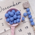 Macro detail of blue striped resin beads in a pink spoon for DIY jewelry making - Style 1 Blue Striped 10mm