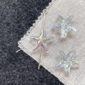 Detailed macro view of colorful AB coated starfish glass beads with metal pin for DIY jewelry - Light Blue Starfish