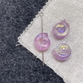 Macro view of iridescent purple glass nautilus beads for DIY jewelry making and craft - Pink Purple Conch