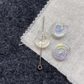 Macro shot of iridescent glass nautilus shell beads for DIY jewelry with silver metal pin - White Conch