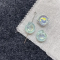 Macro detail of iridescent snail-shaped glass beads for DIY jewelry with silver pins - Blue Green Conch