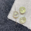 Macro shot of iridescent snail-shaped glass beads with hole for jewelry making - Light Green Conch