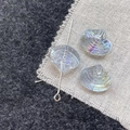 Macro shot of iridescent scallop shell glass beads with pre-drilled holes for DIY jewelry - Light Blue Shell