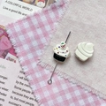 Détail macro de perles en forme de cupcake pour bijoux DIY sur tissu à carreaux - Cupcake Noir