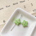 Gros plan d'un pendentif étoile vert clair avec cœur rose et texte Smile sur plat blanc - Étoile Sourire Verte