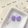 Vue macro de perles violettes avec sourire pour création de bijoux DIY sur céramique - Biscuit Souriant Violet
