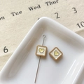Macro detail of square cream and brown heart charms for DIY jewelry making - Khaki Square Heart