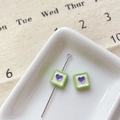 Macro detail of square heart charm beads for DIY jewelry with soft avocado green finish - Green Square Heart