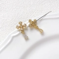 Macro shot of gold-plated cross pendant with shimmering cubic zirconia and pear drop - Zircon Cross / Gold
