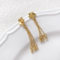 Close-up of gold-plated five-petal flower stud with triple chain tassels and bead details - Flower Tassel / Gold