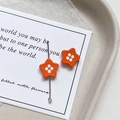 Macro shot of orange star-shaped charm with white dots on a silver needle for DIY jewelry - Star Shape - Orange