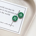 Close-up of green button-shaped star charms with vintage alloy finish on a ceramic tray - Round Shape - Dark Green