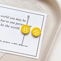 Detailed close-up of bright yellow four-hole button charms for DIY jewelry making - Round Shape - Yellow