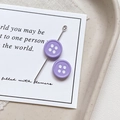 Macro detail of purple round four-hole button bead with metal needle for DIY jewelry making - Round Shape - Purple