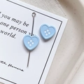 Macro shot of light blue heart-shaped button beads with four holes for DIY jewelry - Heart Shape - Blue