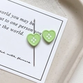 Close-up of heart-shaped four-hole buttons in green lacquer finish for DIY jewelry crafts - Heart Shape - Green