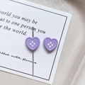 Detailed view of a lavender heart-shaped four-hole button with a metal sewing needle - Heart Shape - Purple