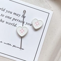 Macro shot of white heart-shaped charms with pink dots on a decorative paper card - Heart Shape - White