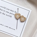 Close-up of heart-shaped button beads in light brown resin with four holes for DIY jewelry - Heart Shape - Khaki