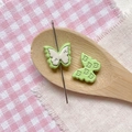 Close-up of light green butterfly beads on a wooden spoon for DIY jewelry making - Green Apricot Double Layer Butterfly