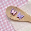 Detail of purple and pink butterfly beads for DIY jewelry on a wooden spoon - Purple Pink Double Layer Butterfly