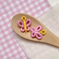 Detail of pink and yellow butterfly beads for DIY jewelry on a wooden spoon - Pink Yellow 3D Butterfly