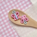 Macro shot of butterfly DIY bead accessories on a wooden spoon with plaid fabric - Pink Blue 3D Butterfly