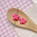 Pink polka dot butterfly charms for DIY bracelets shown on a decorative wooden spoon - Rose Red Polka Dot Butterfly