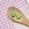 Close-up of green butterfly beads with white dots being threaded for DIY jewelry - Green Polka Dot Butterfly