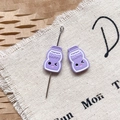 Détail de bouteilles de dessin animé violettes avec texte HAPPY pour la création de bijoux - Bouteille de Lait Violette