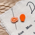 Détail de breloques poissons en émail orange avec rayures pour création de bijoux DIY - Poisson Séché Orange Vif