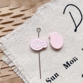 Détail macro de breloques poisson en émail rose et épingles métalliques pour bijoux DIY - Poisson Séché Rose