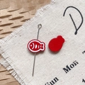 Macro detail of red fish-shaped alloy charms with white bone patterns for DIY jewelry - Red Dried Fish