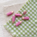 Close-up of pink pencil-shaped enamel alloy beads for DIY jewelry and phone charms - Rose Pink